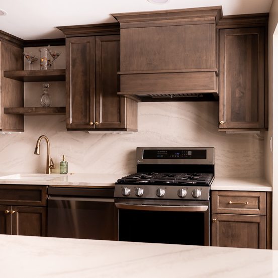 Dark and moody kitchen with maple stained custom cabinets.